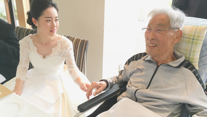 車椅子に座っている老人と白いドレスを着た女性