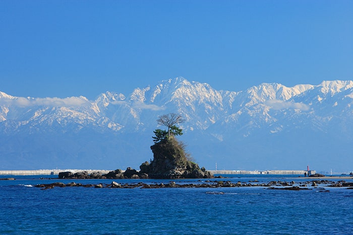 海に映える真っ白な立山連峰と女岩　写真提供:(公社)とやま観光推進機構